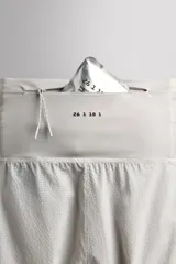 Short deportivo de trail running confeccionado en tejido técnico elástico con textura. Presenta una cintura elástica ancha con compartimentos integrados, bolsillo trasero con cierre y aberturas laterales en el bajo.