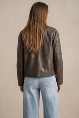Campera de cuero vegano color marrón, con cuello camisero, cierre frontal con botones a presión y mangas largas.