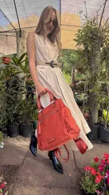 Cartera mochila de diseño versátil, color rosado, confeccionada en material sintético impermeable. Cuenta con doble asa superior, correas ajustables para usar como mochila, compartimento principal con cierre y bolsillo frontal con cierre decorado con tirador largo.