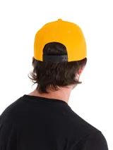 Gorro tipo gorra Caterpillar de color amarillo, con visera curvada y el logotipo de la marca bordado en color negro en la parte delantera.