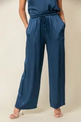 Pantalón palazzo color crudo de viscosa brillante, con elástico y cordón en la cintura y bolsillos laterales.