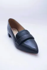 Mocasines negros de cuero con punta fina y detalle de antifaz.