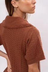 Vestido corto marrón de punto calado con cuello polo y mangas cortas.