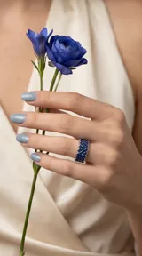 Anillo de plata 925 con diseño de banda ancha, engastado con múltiples circonias azules en un patrón geométrico entrelazado.