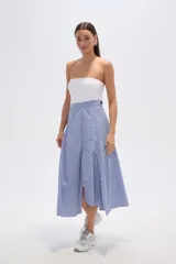 Falda midi de viscosa con estampado de rayas verticales azules y blancas. Presenta un diseño asimétrico con un cruce diagonal en la cintura y un volante fruncido en el ruedo.