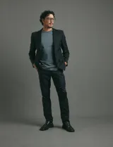 Traje de corte clásico compuesto por saco de dos botones con solapas tradicionales y pantalón de vestir a juego. Confeccionado en tejido liso de poliéster.