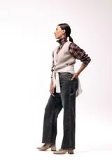 Chaleco tejido de punto con escote en V y cierre frontal con botones. Presenta una silueta recta y un diseño minimalista.