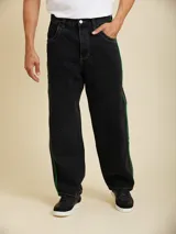Jean de corte baggy fit, color negro, con costuras en contraste color verde y franjas laterales verdes.