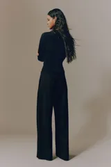Pantalón de tiro alto con piernas amplias, pinzas frontales y raya marcada. Cuenta con cierre oculto, cordón ajustable en la cintura, bolsillos laterales discretos y bolsillos traseros insertados.