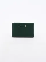 Billetera de tamaño mediano color verde, con textura granulada y detalle metálico horizontal en el frente.