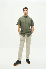 Camisa de manga corta confeccionada en una mezcla de lino y algodón, con cuello clásico, cierre frontal de botones y bolsillo en el pecho con logo bordado.