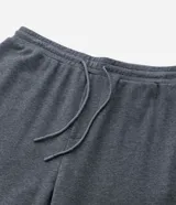 Pantalón tipo jogger de color negro, confeccionado en una mezcla de algodón y poliéster. Presenta cintura elástica con cordón ajustable, bolsillos laterales y puños elásticos en el ruedo.