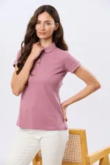 Remera polo de piqué color rosado, con mangas cortas, cuello clásico y cierre frontal de botones.
