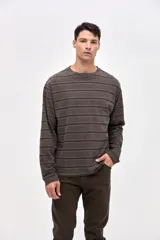 Remera de manga larga con diseño de rayas horizontales en tonos oscuros, confeccionada en algodón lavado con textura suave y calce clásico.