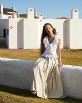 Collar artesanal con dije central de metal con textura orgánica irregular que evoca una ostra. El dije está montado sobre un cordón de algodón natural, permitiendo un uso versátil y regulable.