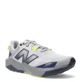 Championes de trail running New Balance Nitrel V6, de color gris con detalles en azul marino y acentos en amarillo flúor. Presentan suela con tecnología AT Tread, refuerzo Toe Protect en la puntera y el logo 'N' en los laterales.