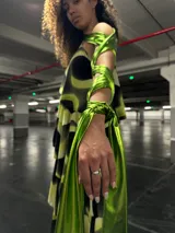 Vestido midi con estampado abstracto en tonos verde lima y negro, con cuello alto y volantes en la falda.