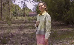 Chaqueta color beige con estampado abstracto en tonos amarillos, con cuello camisero, cierre frontal con botones, bolsillos plaqué y puños camiseros.