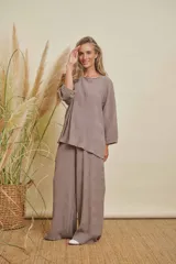 Conjunto de dos piezas color gris topo, con textura plisada. Incluye una blusa de manga larga y cuello redondo, y un pantalón de corte recto.