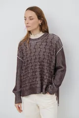 Buzo reversible de tejido de punto con diseño de trenzas, cuello redondo y mangas largas. Presenta una combinación de colores en contraste, con un lado en violeta y el otro en marrón oscuro.