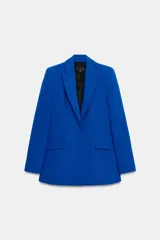 Blazer entallada de color azul vibrante, con cuello de solapa de muesca, manga larga con hombreras y cierre frontal de dos botones forrados. Presenta bolsillos delanteros con solapa y forro interior en color negro.