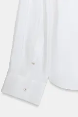 Camisa amplia de cuello solapa con escote en pico y manga larga, en tejido satinado de color bordó. Cuenta con un bolsillo de plastrón en el frente y un diseño holgado.