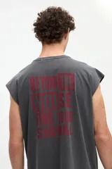 Musculosa gris oscuro con efecto lavado, corte relaxed y estampa en la espalda con la frase "Beyond the noise find your signal" en tono bordó.