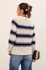 Sweater de punto con rayas horizontales en tonos beige y azul marino, manga larga y cuello redondo.