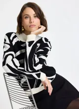 Sweater de punto con diseño estampado abstracto en blanco y negro, cuello alto, mangas largas y puños acanalados.