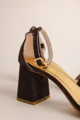 Sandalia de tacón cuadrado medio, confeccionada en tela tipo terciopelo color bordó, con tira delantera simple y pulsera ajustable al tobillo con hebilla metálica.