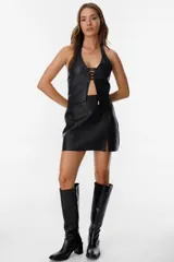 Top marrón de cuero descarne, con cuello halter ajustable con hebilla, escote pronunciado y cierre frontal con cordones.