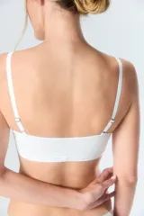 Top deportivo blanco con tirantes ajustables y diseño sin costuras.
