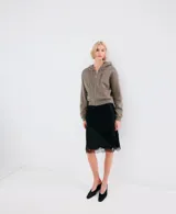 Campera con capucha y cierre frontal de cremallera, de color gris topo, con bolsillos canguro y diseño corto.