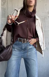 Sweater de tejido de punto color chocolate, con cuello polera, mangas largas con puños acanalados y diseño holgado con aberturas laterales y detalle de botones.