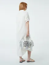 Vestido camisero color crudo, con cuello, botones frontales y mangas 3/4.