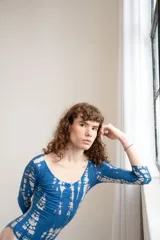 Bodysuit de manga larga con estampado tie-dye en tonos azul y blanco, de corte ajustado.