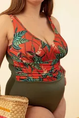 Malla entera de lycra color verde militar con corpiño estampado de hojas y flores en tonos naranja, verde y blanco.