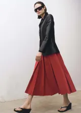 Falda midi de tiro medio con diseño evasé y tablas anchas. Cuenta con forro interior y cierre oculto.