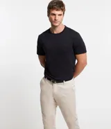Pantalón slim de sastrería de color gris claro, confeccionado en sarga de algodón con elastano, con cierre frontal de botón y cremallera, y bolsillos.