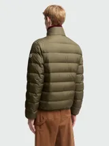 Chaqueta acolchada Moncler modelo Baudinet, color verde oliva, con cierre frontal completo, cuello alto y diseño de costuras horizontales. Incluye bolsillos laterales y logo de la marca en la manga.
