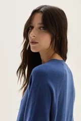 Cardigan de tejido de punto en color azul, con cuello redondo, cierre frontal con botones al tono y mangas largas con puños acanalados. Presenta un diseño clásico y versátil.