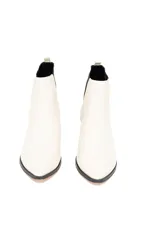 Bota de cuero vacuno liso color blanco hueso, con elásticos laterales negros, taco recto de 4 cm y suela de goma antideslizante.