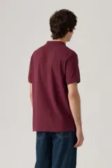 Remera polo Levi's color bordó, de manga corta, con cuello y tapeta de tres botones. Incluye el logo de la marca en el pecho.