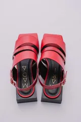 Sandalias rojas de cuero con tres tiras en la capellada, pulsera ajustable y taco cuadrado negro de 3 cm de altura.