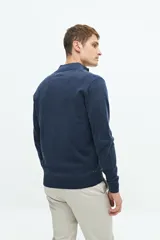 Campera tejida color verde militar, con cuello levemente elevado, cierre entero, logo bordado y fit regular.