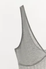 Body gris de punto con escote en pico, tirantes anchos y detalle de tejido rib. Cierre en la parte inferior con botones a presión.