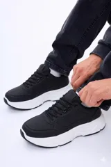 Championes urbanos de diseño moderno, color negro con suela de plataforma blanca. Presentan cordones al tono y una estructura robusta con acabado en cuero sintético.