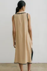 Vestido largo negro sin mangas con cuello camisero y abertura a los costados.