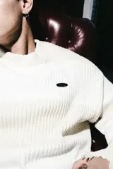 Sweater de punto a rayas horizontales en color amarillo y blanco, con cuello redondo, manga larga y terminación deshilachada en el ruedo y puños.