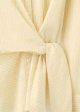 Camisa cruzada de manga larga con lazos para atar en la cintura y cuello camisero, con sutiles rayas verticales.